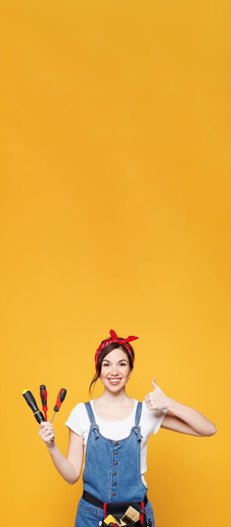 femme avec outils et pouce levée sur fond jaune vertical