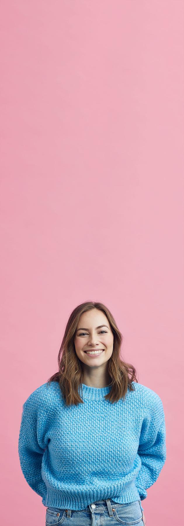 femme en pull over bleu sur fond rose vertical