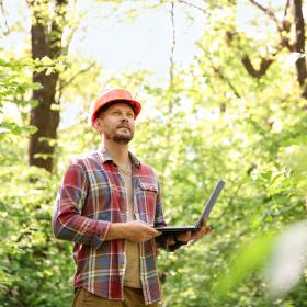 conseiller forestier avec ordinateur portable en forêt