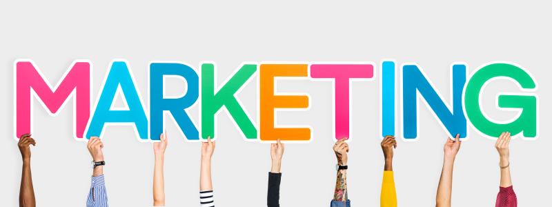 lettres du mot marketing en couleurs tenues par des mains