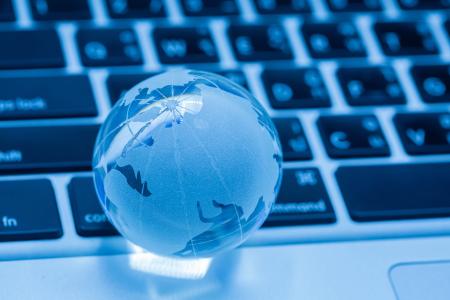 petit globe terrestre bleu sur clavier d'ordinateur, symbole réseau et communication