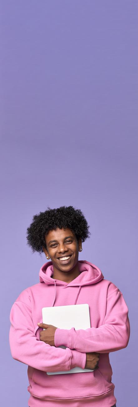 jeune homme avec ordinateur portable habillé en pull rose sur fond violet