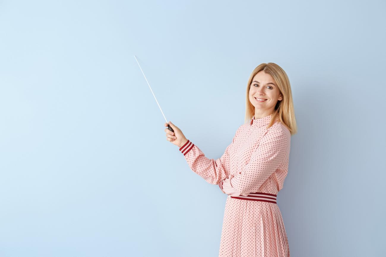 institutrice avec bâton sur fond bleu clair vertical