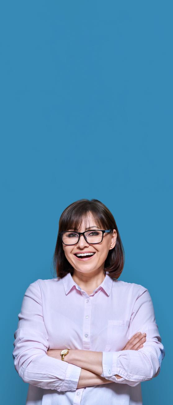 femme souriante aux bras croisés sur fond bleu vertical