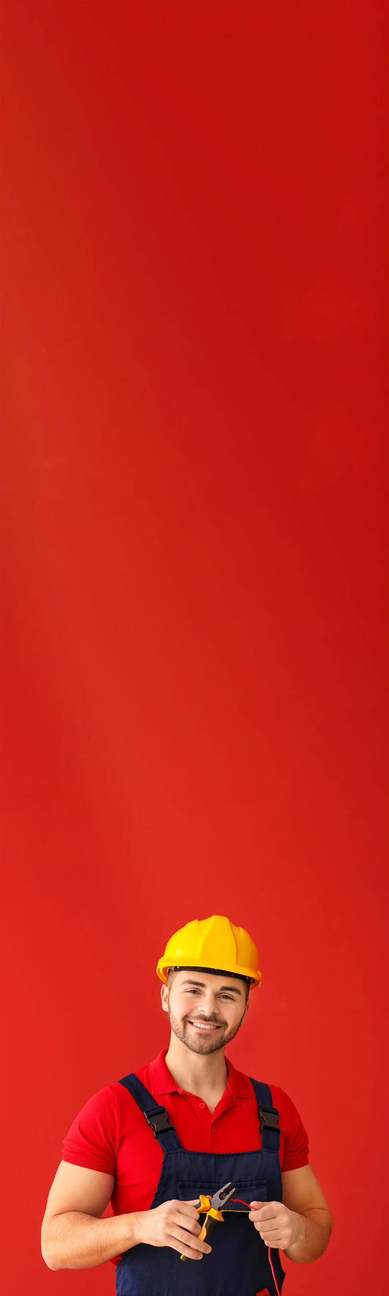 homme électricien avec casque sur fond rouge vertical