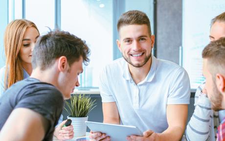 jeune homme avec tablette dans groupe de travail 
