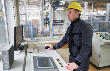 technicien industriel casqué sur poste de contrôle
